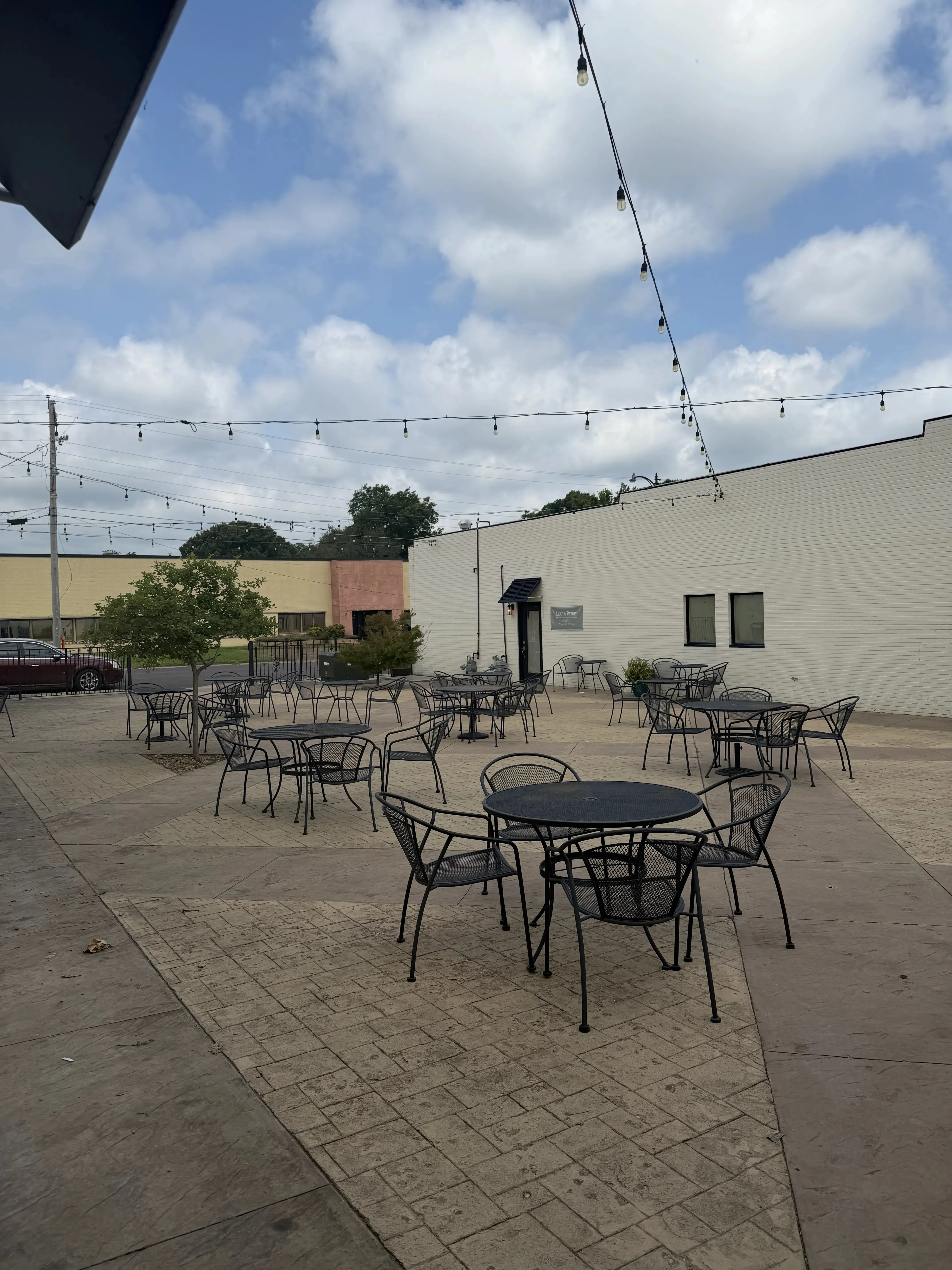 Outdoor patio seating at Green Briar Coffee Co. under string lights